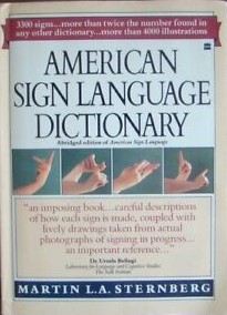 A copy of the textbook with multi-color text that reads "American Sign Langauge Dictionary" along with descriptive text about the content, as well as pictures of handshapes used in ASL.