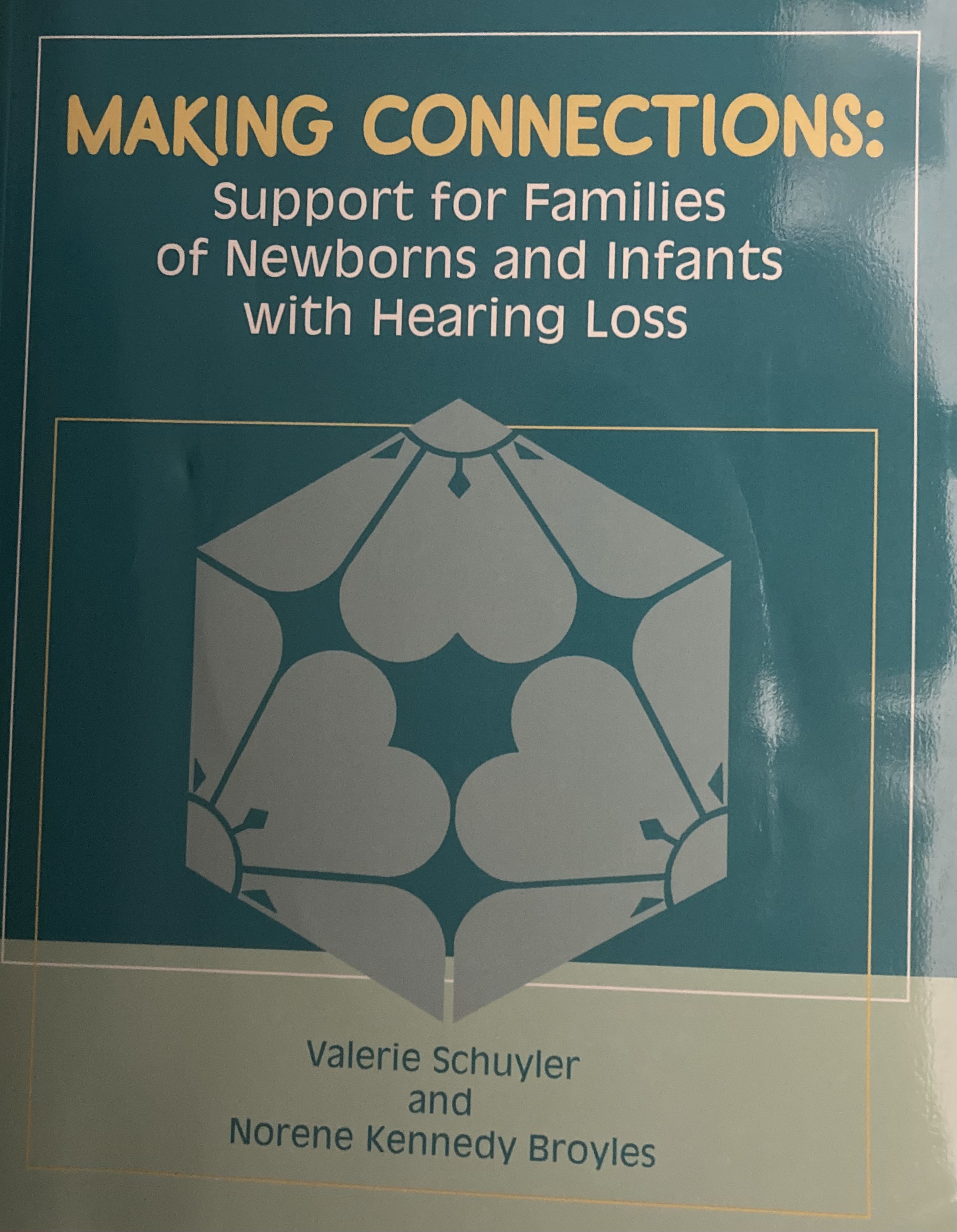 The title "Making Connections: Support for Families of Newborns and Infants with Hearing Loss" is at the top with a green background. The bookcover also features a symmetrical image of hearts and flowers. 