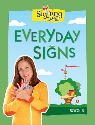 The cover of the book "Everyday Signs" has the title at the top in green along with the Signing Time logo and a green outside border. A smiling woman is at the bottom left wearing a yellow shirt using American Sign Language. In the background, an illustrated outdoor screen with a treehouse.