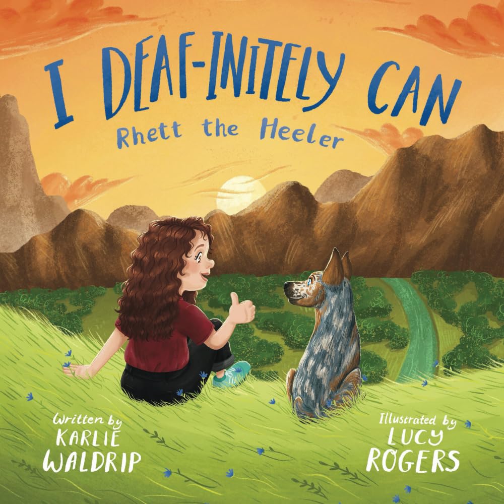 The cover of the book "I Deaf-initely Can, Rhett the Heeler" features an illustrated outdoor image of a sunset over a mountain range. A woman and a dog are sitting in the grass looking at each other.