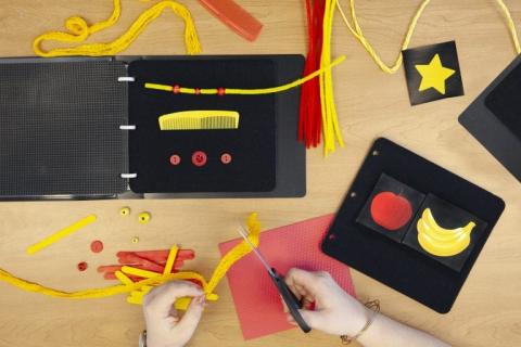 Picture of CVI Book Builder pages, black binders, and other manipulatives.