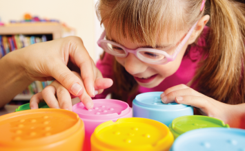 Young student playing with braille toys